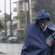 A Postal Service worker delivers mail in the rain in Long Beach, California.